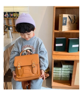 Detail of vintage brown PU leather kids backpack with buckle and clear card slot