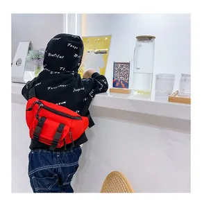 Detail of red nylon kids chest bag featuring functional pockets and adjustable straps