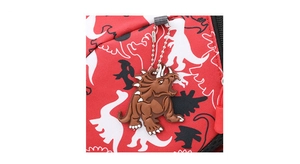 Close-up of red dinosaur backpack with a cute triceratops charm and printed patterns