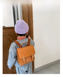 Retro PU leather kids backpack in brown showing size scale on a child model's back