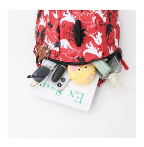 Detail view of red kids backpack with dinosaur prints showing interior storage space