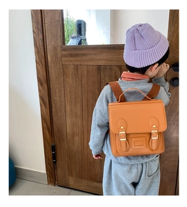 Detail of vintage PU leather backpack for kids with metal buckles and soft texture