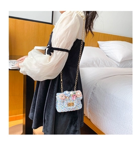 Détail du sac bandoulière enfant en tweed avec fleurs perlées et chaîne dorée sur mannequin