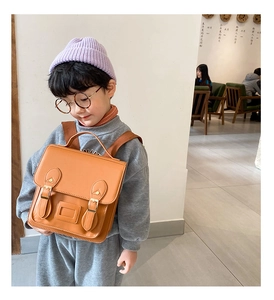 Detail view of a vintage PU leather kindergarten backpack with classic buckle straps