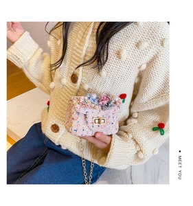 Détail d'un sac bandoulière en tweed rose pour filles avec fleurs et perles