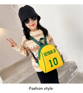 Detail of yellow kids backpack with Neymar Jr 10 print worn by a young girl on stairs