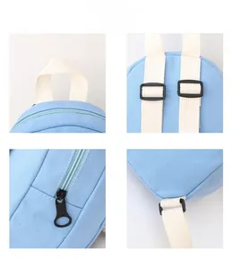 Detail view of light blue canvas backpack showing straps, zipper, and stitching textures