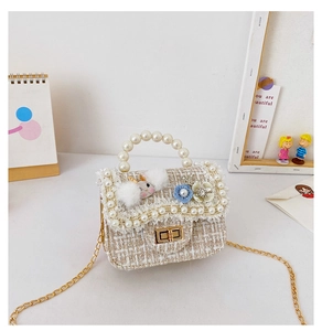 Detail of tweed mini crossbody bag with pearl handle, rabbit decor and golden chain strap