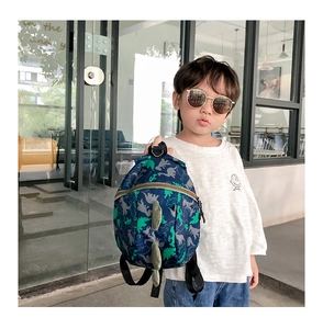Detail of dark blue kids dinosaur backpack featuring 3D back fins and nylon texture