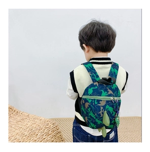 Vue de dos enfant portant un sac à dos dinosaure bleu foncé avec détail de queue en 3D