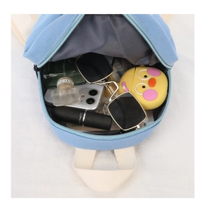 Internal storage capacity of kids canvas backpack showing phone, sunglasses and cosmetics