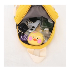 Top view detail of the yellow mini backpack showing interior storage and zipper opening