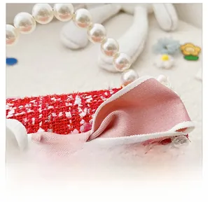 Close-up of red tweed girl bag featuring a pink bow, lace trim and pearl handle detail