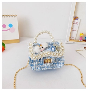 Close-up of blue tweed girls handbag with pearl handle and floral rabbit embellishments