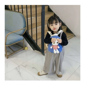 Blue children's backpack featuring a cute white plush bunny on a model's back