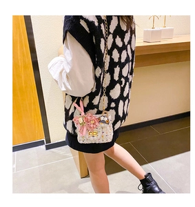 Détail d'un mini sac en tweed pour fille avec fleurs décoratives et bandoulière
