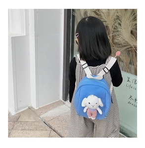 Blue kids backpack with a cute white plush rabbit doll being worn outdoors