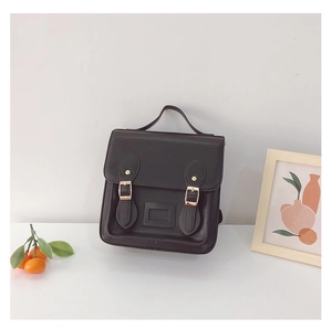 Close-up of vintage PU leather toddler backpack with gold buckles and clear card slot