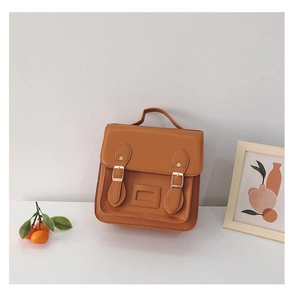 Close-up of vintage brown PU leather backpack with dual buckle straps and top handle