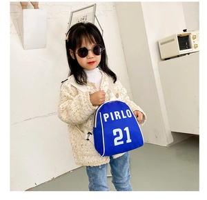 Detail view of child wearing royal blue mini backpack with white Pirlo 21 logo