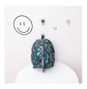 Detail of navy blue kids backpack with green dinosaur prints and 3D fin decoration