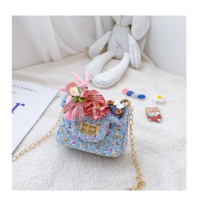 Détail du sac à bandoulière en tweed bleu pour enfant avec ruban rose et fermoir doré