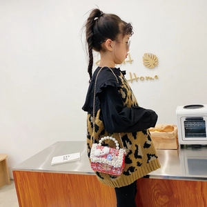 Kids red tweed crossbody bag with pearl handle and plush doll charm on a gold chain strap
