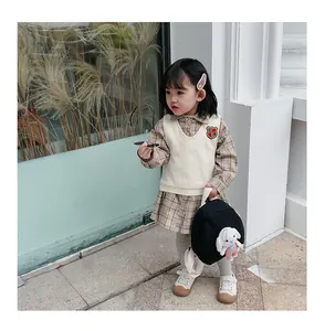 Detailed view of a small black kids' backpack with a cute white rabbit plush doll charm
