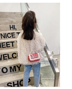 Red tweed child crossbody bag with pearl handle and metal chain shown on model