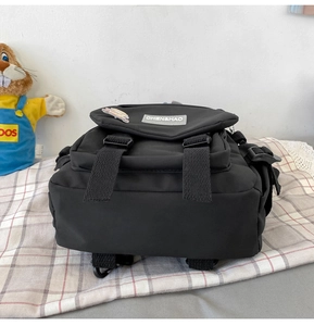 Gros plan du sac à dos noir en toile avec rabat et fermoirs à boucle de sécurité