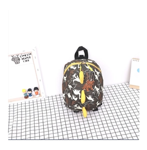 Détail d'un sac à dos enfant motif dinosaure avec plaques en silicone jaunes et un pendentif
