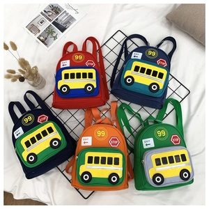 Detail showing five colorful canvas schoolbags with yellow bus patterns for toddlers