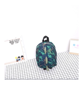 Détail d'un sac à dos enfant bleu marine avec motifs dinosaures et crêtes 3D