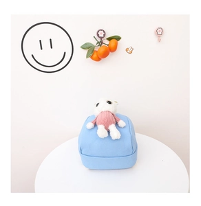 Detail of light blue canvas kids backpack with a cute white plush bunny doll decoration