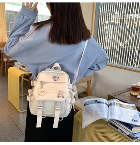 Détail d'un sac à dos en toile crème avec des écussons mignons et multi-poches