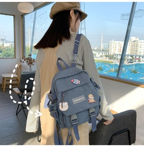 Détail de sac à dos bleu avec écussons de dessin animé mignons et boucle de fermeture