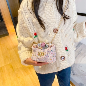 Sac bandoulière enfant en tweed rose avec fleur et chaîne porté par une fillette