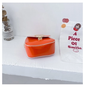 Vue détaillée du mini sac cœur orange avec fermoir doré et bandoulière chaîne