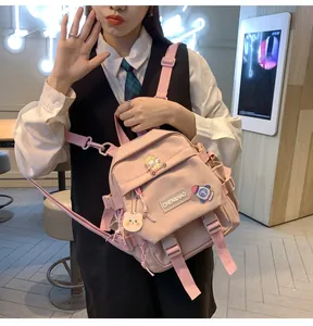 Détail du sac à dos rose multi-poches pour étudiantes avec pendentif ours et écusson