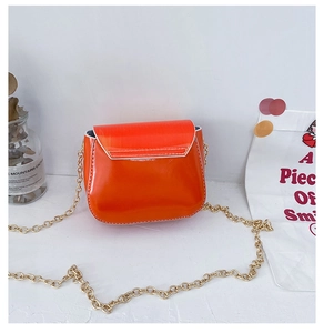 Détail d'un sac à chaîne orange vif avec finition brillante et surpiqûres blanches