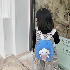 Blue kids backpack with a cute white bunny plush toy shown on a child outdoors