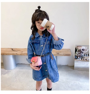Détail du mini sac bandoulière rose en forme de cœur avec chaîne sur robe denim
