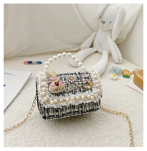 Detail of tweed girls' crossbody bag with pearl handle, daisy accents and metal chain
