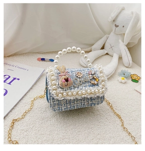 Detail of tweed girls handbag with pearl handle, chain strap and cute bunny patch