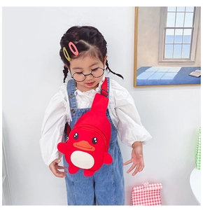 Close-up of red cartoon duck crossbody bag with 3D wings on a young child model