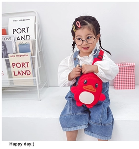 Toddler modeling a red duck chest bag with adjustable strap in a cozy home setting