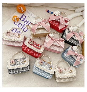 Detail of tweed children handbags with pearl handles and cute rabbit charms