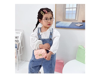 Pink quilted mini jelly bag with pearl handle and golden twist lock on a child model