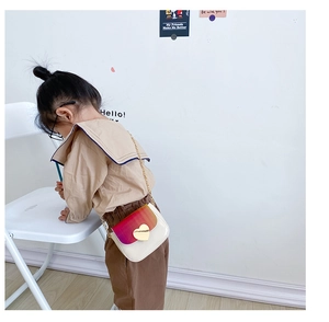 Détail du sac enfant avec rabat dégradé rose et fermoir doré en forme de cœur