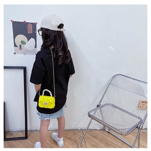 Detail of yellow quilted jelly bag with pearl handle and gold chain strap for kids